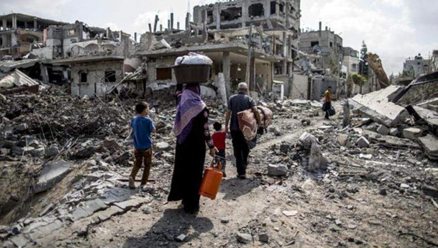 عائلة غزّية تمشي على ركام منزلها المدمّر جراء العدوان الاسرائيلي أيار 2021 عائلة غزّية تمشي على ركام منزلها المدمّر جراء العدوان الاسرائيلي أيار 2021