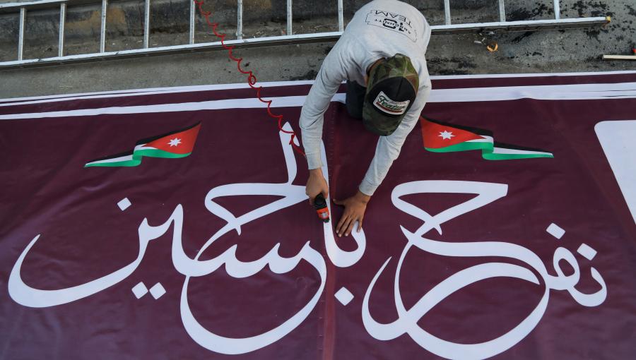 من تجهيزات الاحتفال بعقد قران ولي العهد عامل يجهز لافتة "نفرح بالحسين" لتعليقها في أحد الشوارع من تجهيزات الاحتفال بعقد قران ولي العهد عامل يجهز لافتة "نفرح بالحسين" لتعليقها في أحد الشوارع