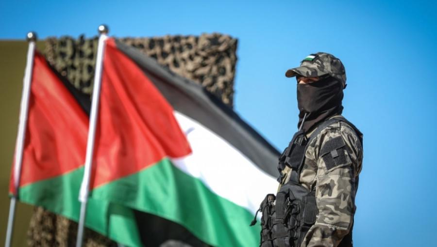 أحد رجال المقاومة الفلسطينية مع علم فلسطين أحد رجال المقاومة الفلسطينية مع علم فلسطين