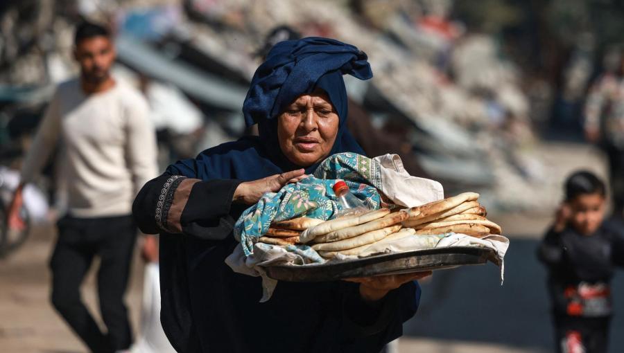 فلسطينية تحمل الخبز خارج مدرسة تابعة للأمم المتحدة في غزة فلسطينية تحمل الخبز خارج مدرسة تابعة للأمم المتحدة في غزة | المصدر: فرانس برس
