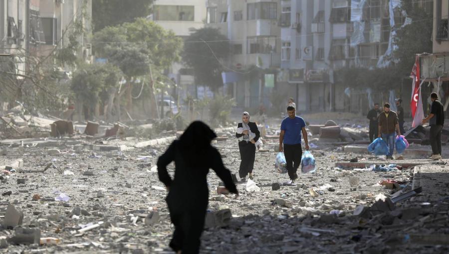 فلسطينيون يسيرون وسط دمار خلّفه القصف الإسرائيلي في غزة فلسطينيون يسيرون وسط دمار خلّفه القصف الإسرائيلي في غزة