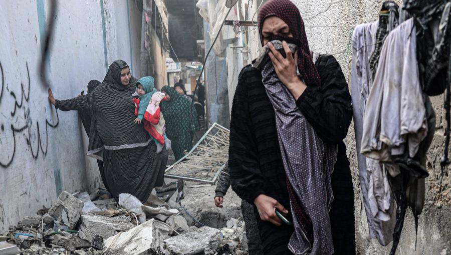 فلسطينيات يعبرن من زقاق في رفح دمرته الغارات الإسرائيلية فلسطينيات يعبرن من زقاق في رفح دمرته الغارات الإسرائيلية | المصدر: الوكالة الفرنسية للأنباء