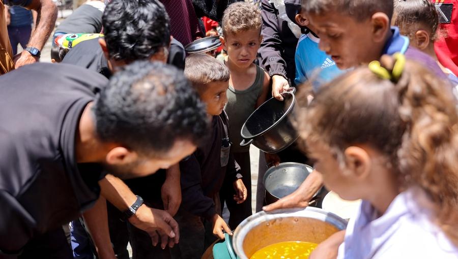 أطفال يصطفون للحصول على الطعام في مدرسة تابعة للأونروا في مخيم جباليا للاجئين الفلسطينيين في شمال قطاع غزة أطفال يصطفون للحصول على الطعام في مدرسة تابعة للأونروا في مخيم جباليا للاجئين الفلسطينيين في شمال قطاع غزة في 17/6/2024 | المصدر: وكالة فرانس برس