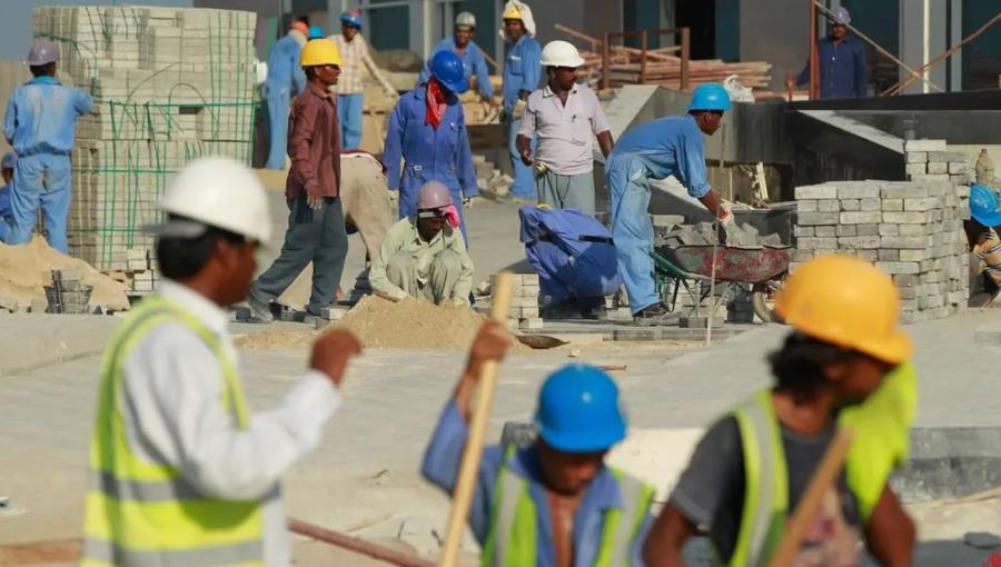 عمال وافدون يعملون في موقع تحت الإنشاء عمال وافدون يعملون في موقع تحت الإنشاء