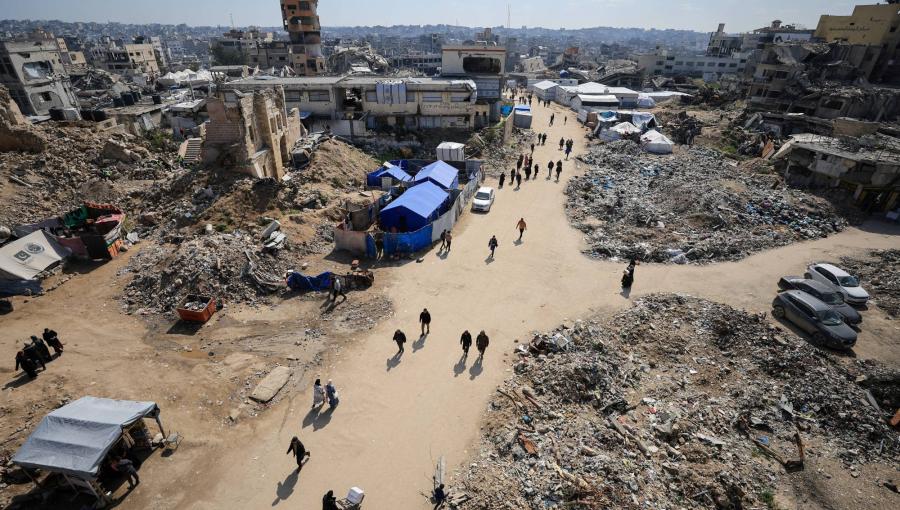 فلسطينيون يسيرون بالقرب من أنقاض المباني في غزة فلسطينيون يسيرون بالقرب من أنقاض المباني في غزة | المصدر: رويترز