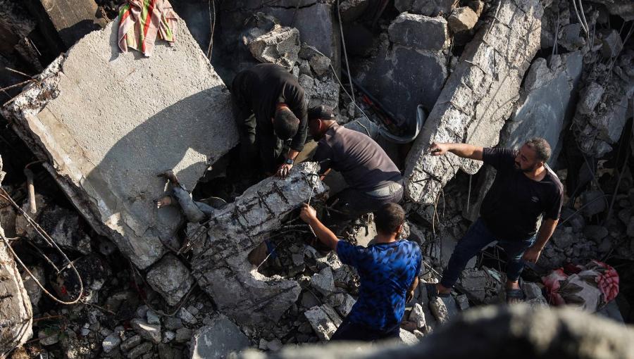 فلسطينيون يبحثون عن جثة تحت أنقاض منزل دمرته غارات الاحتلال على مدينة غزة | وكالة الأنباء الفرنسية