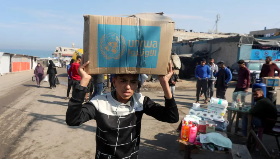 طفل غزي يحمل صندوق مساعدات من الأونروا | أرشيفية رويترز