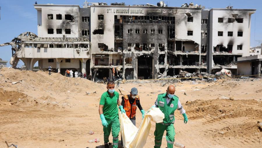 كوادر طبية تنقل جثامين من ساحة مجمع الشفاء الطبي