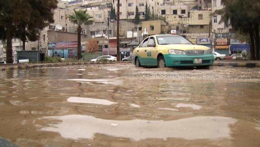 تكسي يسير في أحد شوارع العاصمة عمان وقد غمرته مياه الأمطار | مواقع التواصل