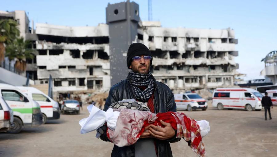 فلسطيني يحمل جثمان رضيعته البالغة 3 أشهر بعد وفاتها جراء البرد في مدينة غزة | وكالة الأنباء الفرنسية