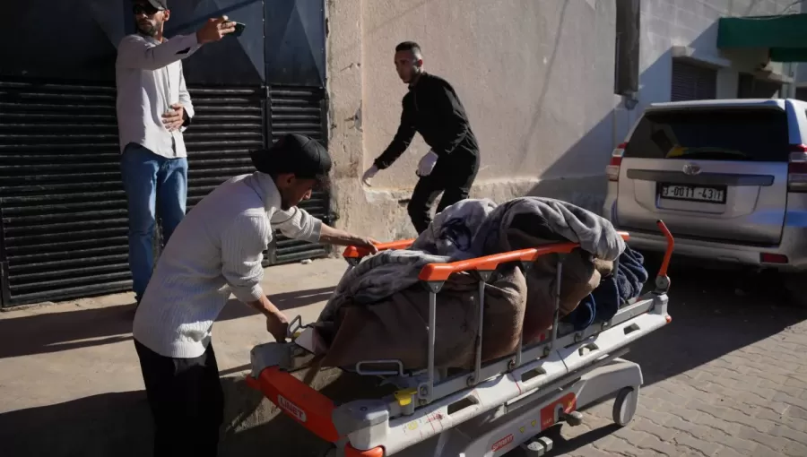 رجل فلسطيني يدفع نقالة تحمل جثمان شهيدين في مستشفى شهداء الأقصى 4/2/2026 | أسوشييتد برس