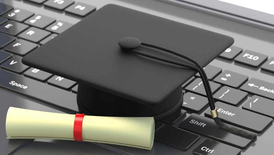 رسم قبعة تخرج وشهادة على حاسوب محمول | تعبيرية freepik