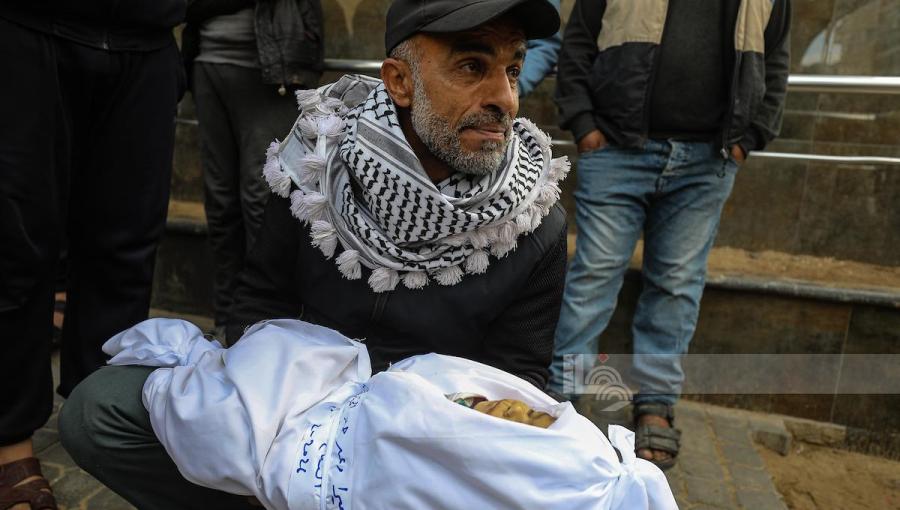فلسطيني يحمل جثمان طفله الذي استشهد إثر غارات إسرائيلية على قطاع غزة 4/2/2026 | وفا