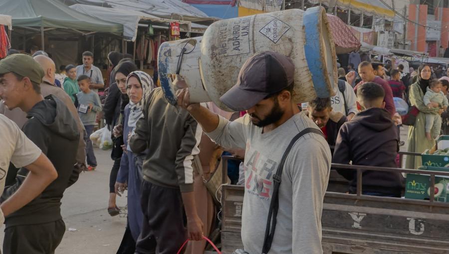 فلسطيني يحمل على كتفه أسطوانة غاز | وكالة الأنباء الفرنسية