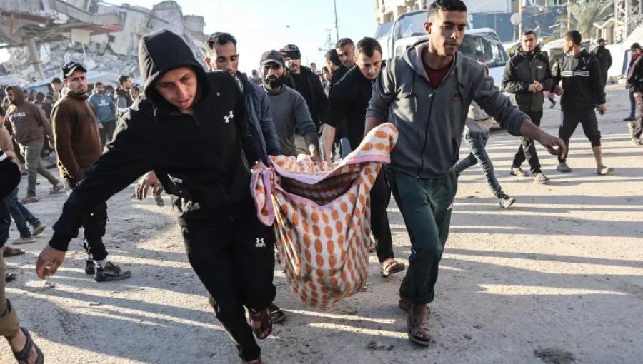 فلسطينيون يحملون جثمان أحد الشهداء بعد غارة جوية إسرائيلية على مدينة غزة 8/3/2026 | وكالة الأنباء الفرنسية