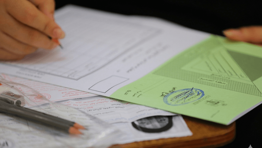 طالب يدون إجاباته في ورقة امتحان توجيهي