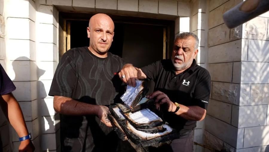 فلسطينيان يمسكان مصاحف محترقة جراء هجوم المستوطنين على أحد المساجد في الضفة 24/7/2026 | الأناضول