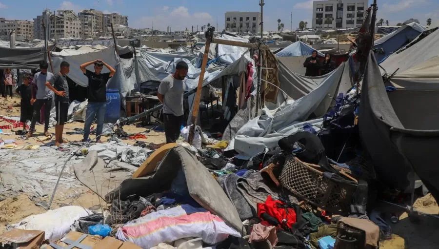 فلسطينيون يتفقدون موقع غارة إسرائيلية استهدفت خيمة في مخيم لإيواء النازحين بمدينة غزة | رويترز