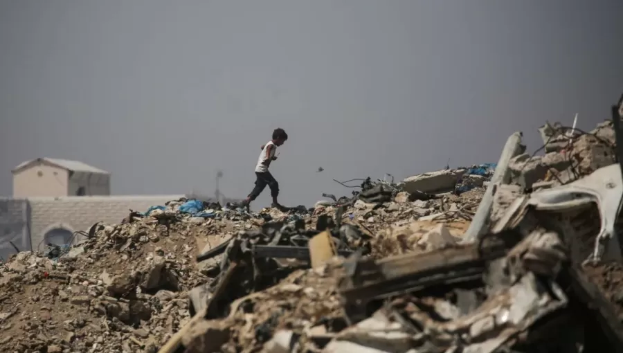 صبي فلسطيني يمشي وسط الأنقاض قرب مخيم للنازحين في منطقة النصيرات وسط غزة 28/6/2026 | وكالة الأنباء الفرنسية