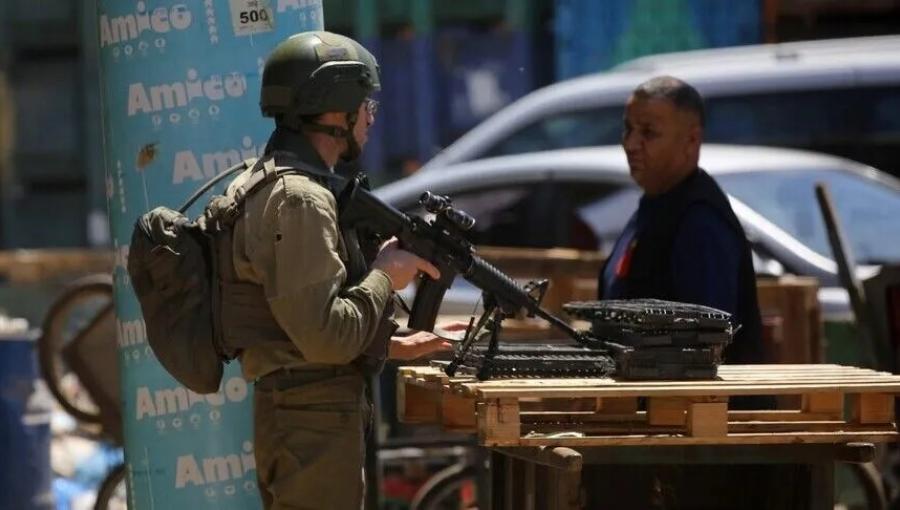 جندي من جيش الاحتلال يعيق تحرك فلسطيني في إحدى بلدات الضفة الغربية | الأناضول
