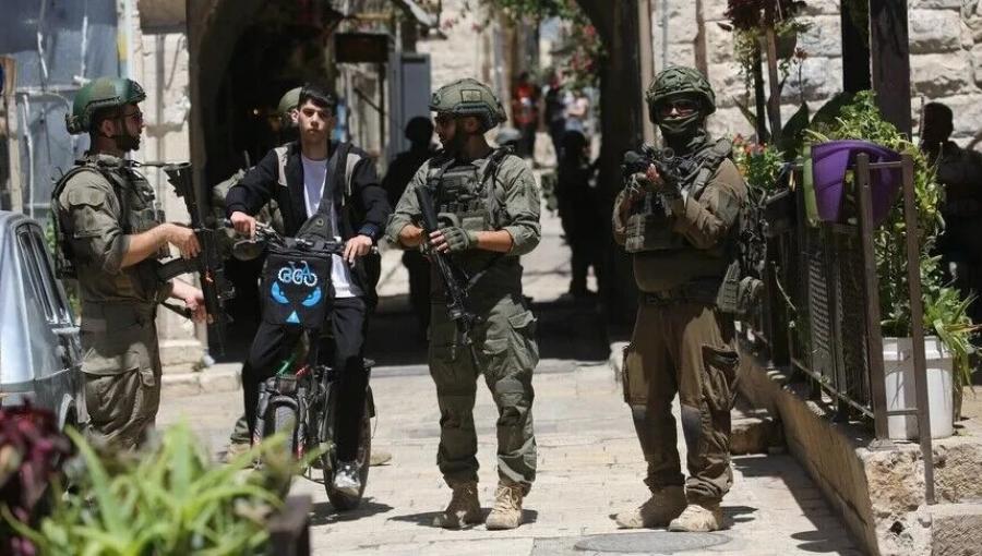 عدد من جنود الاحتلال يعيقون تحرك أحد الفتية في الضفة الغربية | الأناضول