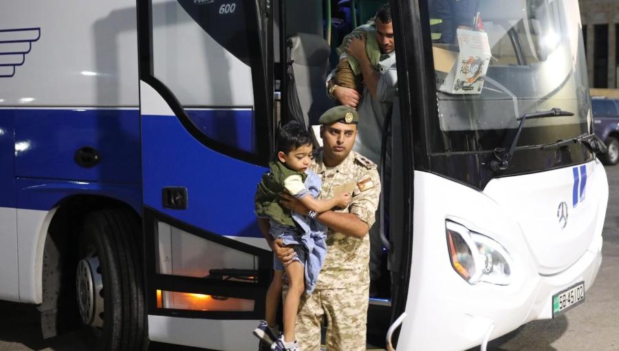 طفل من غزة يحمله أحد أفراد القوات المسلحة خلال رحلة العودة إلى قطاع غزة 26/8/2026