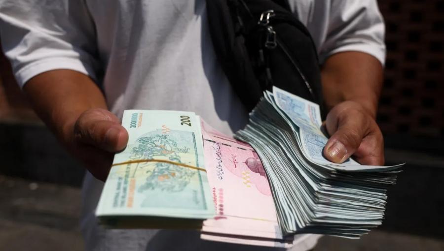 شخص يحمل أوراقا من الريال الإيراني في البازار الكبير بطهران 17/8/2026 | رويترز