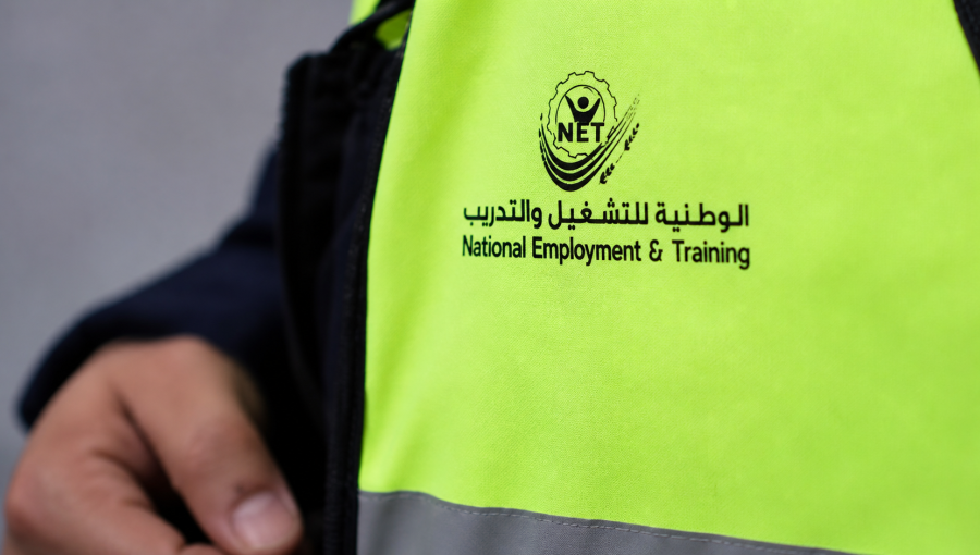 شخص يرتدي سترة عليها شعار الوطنية للتشغيل والتدريب