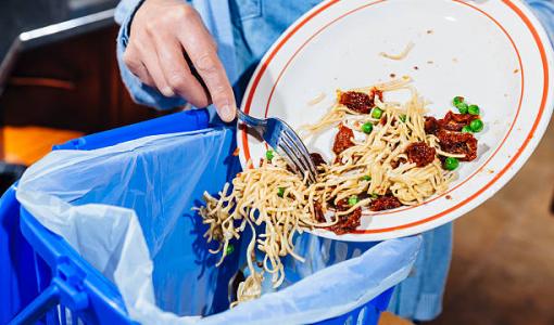 هدر الغذاء شخص يتخلص من بواقي الطعام |istockphoto