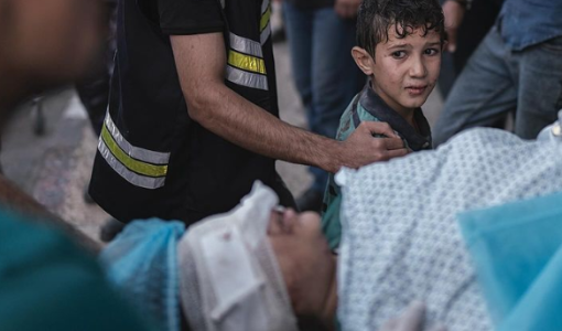 طفل ينظر مرعوبا إلى والدته التي أصيبت في غارة جوية إسرائيلية