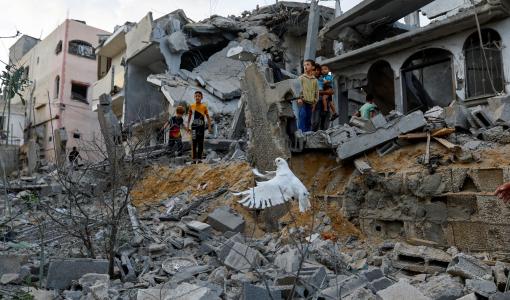 أطفال يقفون على ركام منازل دمرتها طائرات الاحتلال في غزة