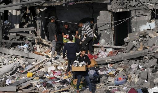 فلسطينيون يجمعون أغراضهم من منزلهم الذي دمرته طائرات الاحتلال في مخيم النصيرات 18/12/2023 | المصدر: وكالة الصحافة الفرنسية