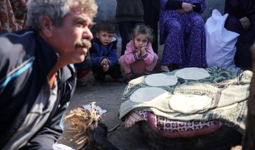 أطفال نازحون ينتظرون للحصول على خبز في أحد مخيمات النزوح وسط غزة 21/12/2023 | المصدر: تايمز أوف غزة