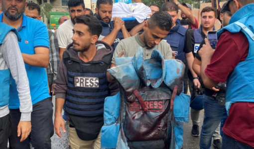 صحفي يحمل السترة الواقية لزميله محمود صبح الذي استشهد في غارة إسرائيلية | المصدر: رويترز