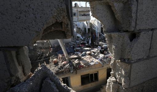 فلسطينيون يتفقدون موقع غارة إسرائيلية على منزل في رفح جنوب قطاع غزة 7/2/2024 | المصدر: رويترز