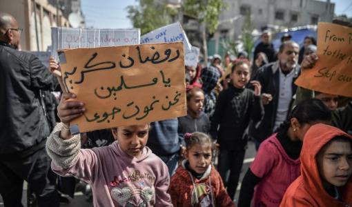 أطفال من غزة يرفعون لافتات تعبر عن وضعهم وجوعهم في القطاع مع حلول شهر رمضان | المصدر: الأناضول