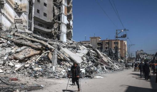 رجل غزي مصاب بسبب عدوان الاحتلال على غزة يمشي بجانب أنقاض بين دمرته غارات الاحتلال على رفح | المصدر: وكالة الأنباء الفرنسية