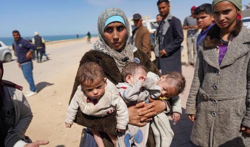 سيدة تنزح بأطفالها الثلاثة مشيا على الأقدام من مجمع الشفاء الطبي في مدينة غزة إلى المنطقة الوسطى 21/3/2024 | المصدر: وكالة الأنباء الفرنسية