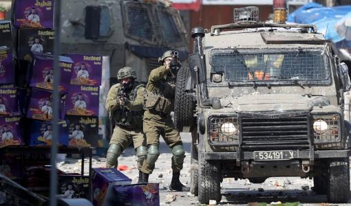 جنود من جيش الاحتلال الإسرائيلي قرب آلية لهم خلال اقتحام سابق لمدن الضفة الغربية المحتلة | المصدر: الأناضول