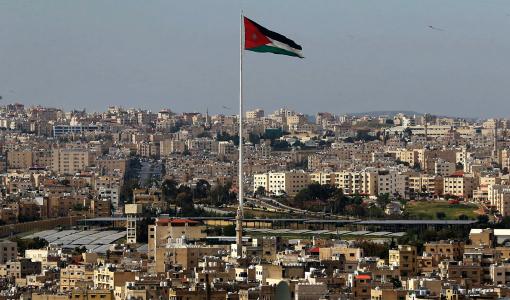 أجزاء من مدينة عمان يتوسطها علم الأردن