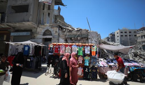 صورة أرشيفية خلال أحد الأعياد في غزة تظهر نساء يتسوقن في سوق مقام على أنقاض المباني التي دمرها الاحتلال | المصدر: getty images