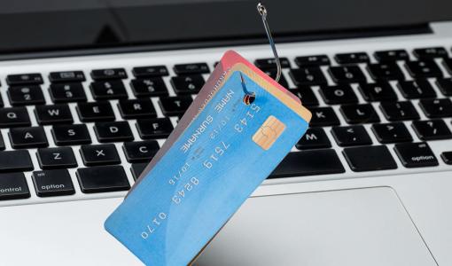 بطاقات بنكية مثقوبة فوق جهاز حاسوب | المصدر: freepik