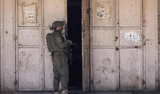 جندي من جيش الاحتلال الإسرائيلي يقف عند متجر خلال مداهمة بلدة طولكرم في الضفة الغربية | المصدر: وكالة الأنباء الفرنسية