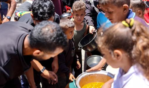 أطفال يصطفون للحصول على الطعام في مدرسة تابعة للأونروا في مخيم جباليا للاجئين الفلسطينيين في شمال قطاع غزة أطفال يصطفون للحصول على الطعام في مدرسة تابعة للأونروا في مخيم جباليا للاجئين الفلسطينيين في شمال قطاع غزة في 17/6/2024 | المصدر: وكالة فرانس برس