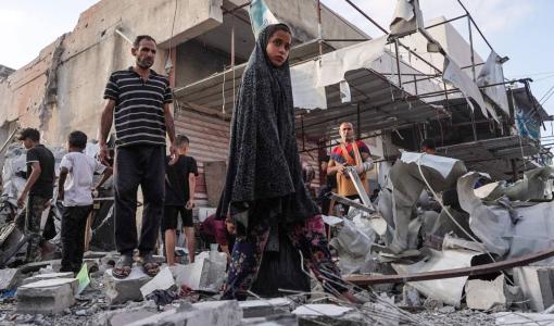 فلسطينيون يتفقدون أنقاض منزل دمره قصف الاحتلال الإسرائيلي على مخيم النصيرات في قطاع غزة | المصدر: وكالة الأنباء الفرنسية