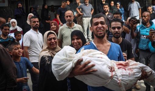 فلسطيني يحمل جثمان شهيد إثر غارة إسرائيلية على مخيم البريج للاجئين وسط غزة 18/9/2024 | المصدر: وكالة الأنباء الفرنسية