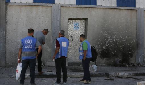 موظفو وكالة الأونروا في مخيم المغازي في غزة يقفون عند باب أحد مقرات الوكالة | المصدر: وكالة الأنباء الألمانية