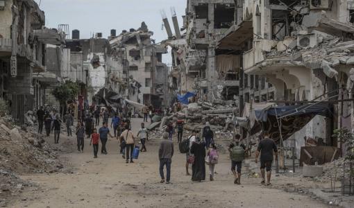 فلسطينيون يسيرون بين الأنقاض في مخيم البريج للاجئين في جنوب قطاع غزة 17/92024 | المصدر: الوكالة الأوروبية للصور الصحفية