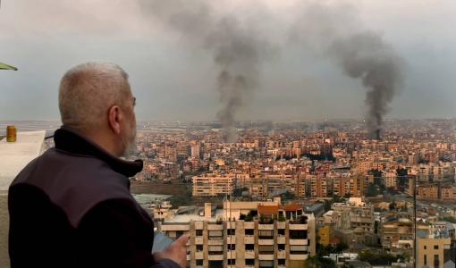 لبناني يشاهد الدخان يتصاعد من الضاحية الجنوبية لبيروت بعد قصف إسرائيلي | المصدر: أسوشييتد برس