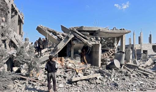 فلسطينيون يبحثون بين أنقاض مبنى دمره القصف الإسرائيلي في بيت لاهيا شمال قطاع غزة | المصدر: وكالة الصحافة الفرنسية